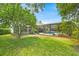 Expansive backyard features a screened-in pool area, mature trees, and lush green lawn at 2602 Tryon Pl, Windermere, FL 34786