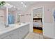 Bright bathroom with double sinks and vanity mirror leading into a bedroom at 2602 Tryon Pl, Windermere, FL 34786