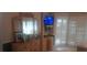 Well-lit bedroom featuring plantation shutters, wood dresser, and a wall-mounted TV at 2602 Tryon Pl, Windermere, FL 34786