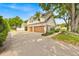 Spacious driveway leading to a three-car garage, surrounded by lush landscaping and mature trees at 2602 Tryon Pl, Windermere, FL 34786