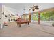 Spacious screened patio featuring a pool table, ceiling fans, and views of the lush backyard at 2602 Tryon Pl, Windermere, FL 34786