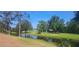 A serene pond is surrounded by lush greenery and a picnic shelter in the distance at 2602 Tryon Pl, Windermere, FL 34786