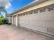 Three-car garage with decorative windows and a patterned driveway at 2673 Beckett Run, The Villages, FL 32162