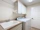 Bright laundry room with washer, dryer and utility sink at 2673 Beckett Run, The Villages, FL 32162