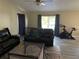 Living room with two black reclining sofas, a Peloton bike, and a dog crate at 3726 Imperial Dr, Winter Haven, FL 33880