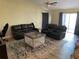 Spacious living room featuring two black leather reclining sofas and a playpen at 3726 Imperial Dr, Winter Haven, FL 33880