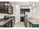 Modern kitchen with dark cabinetry, granite countertops, and stainless steel appliances at 555 Meadow Pointe Dr, Haines City, FL 33844