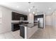 Modern kitchen with dark cabinetry, granite countertops, and stainless steel appliances at 555 Meadow Pointe Dr, Haines City, FL 33844