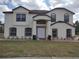 Charming two-story home with a well-manicured lawn, a white exterior, and black trim on the windows and roofline at 18744 Sabal St, Orlando, FL 32833