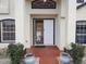 Front entrance of the home with an open front door, potted plants, and a brick-paved entryway at 18744 Sabal St, Orlando, FL 32833