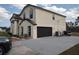 Side view of the home showing the garage, driveway, landscaping, and some trees at 18744 Sabal St, Orlando, FL 32833