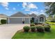 Gray house with 3-car garage and lush landscaping at 768 Bradford Loop, The Villages, FL 32163