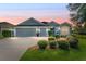 Gray house with 3-car garage, well manicured lawn, and landscaping at 768 Bradford Loop, The Villages, FL 32163