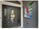 Dark gray front door with glass accents and hummingbird decor at 768 Bradford Loop, The Villages, FL 32163