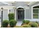 Elegant dark gray front door with glass accents and landscaping at 768 Bradford Loop, The Villages, FL 32163
