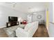 Bright living room features hardwood floors, comfy seating, and a large TV at 768 Bradford Loop, The Villages, FL 32163