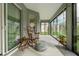 Peaceful sunroom boasts hardwood floors, a rocking chair, and ample natural light at 768 Bradford Loop, The Villages, FL 32163