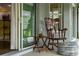 Serene sunroom with rocking chair, side table and view into kitchen at 768 Bradford Loop, The Villages, FL 32163