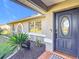 House entrance with dark blue door and landscaping at 1072 Se 155Th St, Summerfield, FL 34491