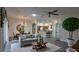Inviting living room with wood-look flooring, neutral tones, and view to kitchen at 17755 Se 85Th Ellerbe Ave, The Villages, FL 32162