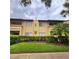 Exterior view of a condo building with landscaping and a grassy lawn at 6116 Curry Ford Rd # 229, Orlando, FL 32822