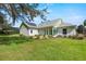 Back exterior showcases a sunroom, solar panels, and grassy yard at 1162 Fiesta Key Cir, Lady Lake, FL 32159