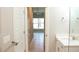 Hallway showcasing tile flooring, white doors, and a view into a light-filled room at 2114 Waitman, Leesburg, FL 34748