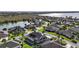 Aerial view of a house with a private screened-in pool, lake view, and solar panels at 4049 Nostalgia Ter, The Villages, FL 32163