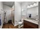 Bathroom with brown wood floors, single sink vanity, and a shower with glass doors at 4049 Nostalgia Ter, The Villages, FL 32163