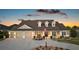 Charming home featuring a three-car garage, dormer windows, a cozy front porch, and a well-manicured lawn at 4049 Nostalgia Ter, The Villages, FL 32163