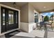 Inviting front porch with a seating area and stylish black door, offers an open view to the neighborhood at 4049 Nostalgia Ter, The Villages, FL 32163