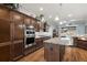 Modern kitchen features custom cabinets, stainless steel appliances, an island and wood-look ceramic tile floors at 4049 Nostalgia Ter, The Villages, FL 32163
