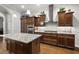 Well-equipped kitchen featuring granite countertops, dark wood cabinetry, stainless steel appliances, and a central island at 4049 Nostalgia Ter, The Villages, FL 32163