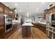 Spacious kitchen with dark wood cabinets, stainless steel appliances, granite countertops, and a large island at 4049 Nostalgia Ter, The Villages, FL 32163