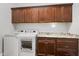Laundry room with dark brown cabinets, granite countertop, washer, and dryer at 4049 Nostalgia Ter, The Villages, FL 32163