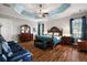 Spacious main bedroom featuring tray ceiling, wood floors, and dark wood furniture at 4049 Nostalgia Ter, The Villages, FL 32163