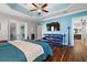 Relaxing main bedroom features a blue accent wall and a seating area with large screen tv at 4049 Nostalgia Ter, The Villages, FL 32163