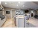 Outdoor kitchen featuring a built-in bar, grill, sink, refrigeration, ceiling fans, and a television for entertainment at 4049 Nostalgia Ter, The Villages, FL 32163