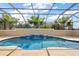 A beautiful screened-in pool with a waterfall feature surrounded by lush landscaping at 4049 Nostalgia Ter, The Villages, FL 32163