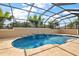 Beautiful screened-in pool with waterfall feature and surrounding landscaping at 4049 Nostalgia Ter, The Villages, FL 32163
