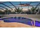 A stunning screened-in pool with waterfall feature, enhanced by evening sky and subtle lighting at 4049 Nostalgia Ter, The Villages, FL 32163
