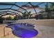 A scenic screened-in pool at sunset with a waterfall feature and outdoor seating area at 4049 Nostalgia Ter, The Villages, FL 32163
