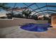 Screened pool with a beautiful pool deck, a unique design, and a waterfall feature with steps leading to the water at 4049 Nostalgia Ter, The Villages, FL 32163