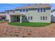 View of the back of the home with a covered patio and green lawn with freshly laid straw at 6208 Trailblaze Bnd, St Cloud, FL 34771