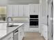 Gourmet kitchen with stainless appliances, tile backsplash, and modern faucet at 6208 Trailblaze Bnd, St Cloud, FL 34771