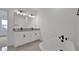 Bathroom with a soaking tub, dual sinks, and sleek, modern lighting at 6608 Quest St, St Cloud, FL 34771
