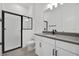Modern bathroom featuring a tiled shower with black frame, a large mirror, and vanity with a gray countertop at 6608 Quest St, St Cloud, FL 34771