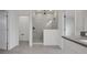 Modern bathroom featuring glass-enclosed shower with rainfall shower head, white vanity and gray tile at 6608 Quest St, St Cloud, FL 34771