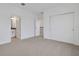 Bright bedroom with neutral carpet, closet, and bathroom entrance, offering convenience and comfort at 6608 Quest St, St Cloud, FL 34771