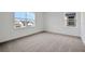 Bright bedroom with neutral carpet, two windows providing natural light, and freshly painted white walls at 6608 Quest St, St Cloud, FL 34771